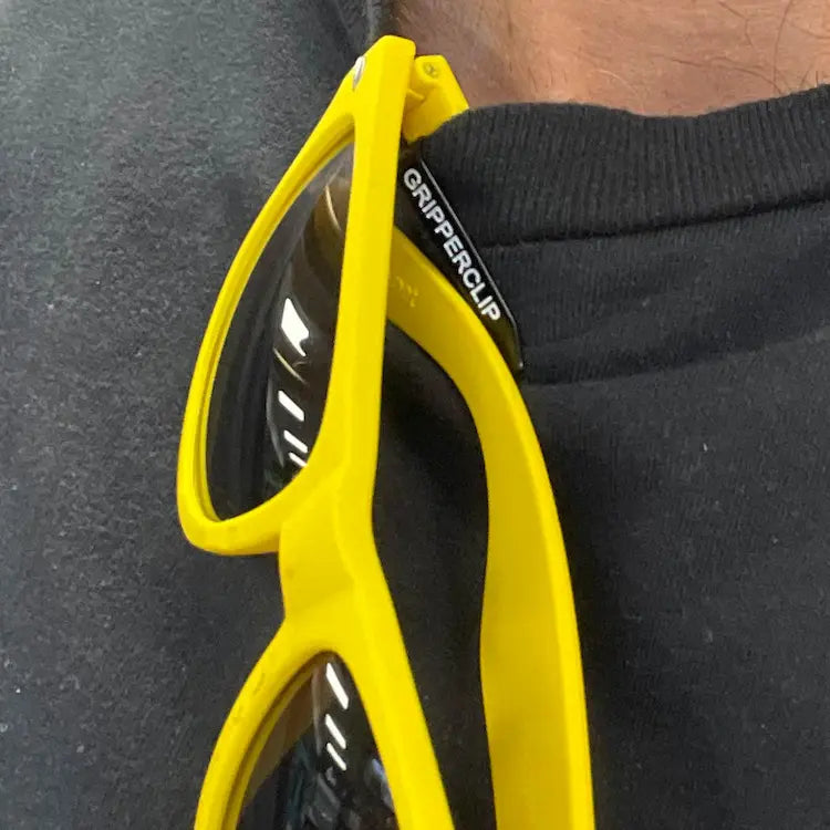 GripperClip on pair of sunglasses clipped on shirt keeping eyewear safe by protecting glasses from falls, drops and damage.